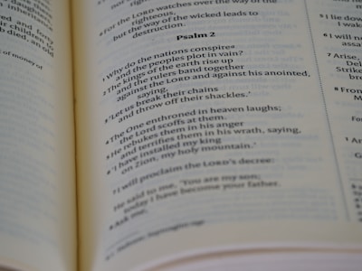 Open book displaying printed text, specifically a passage from a psalm, with a focus on neat typography and verses marked in sequence. The book is laid out on a flat surface with visible binding.