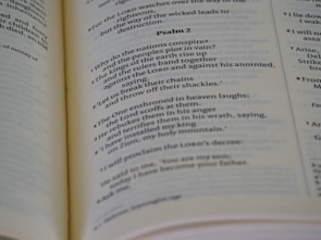 Open book displaying printed text, specifically a passage from a psalm, with a focus on neat typography and verses marked in sequence. The book is laid out on a flat surface with visible binding.
