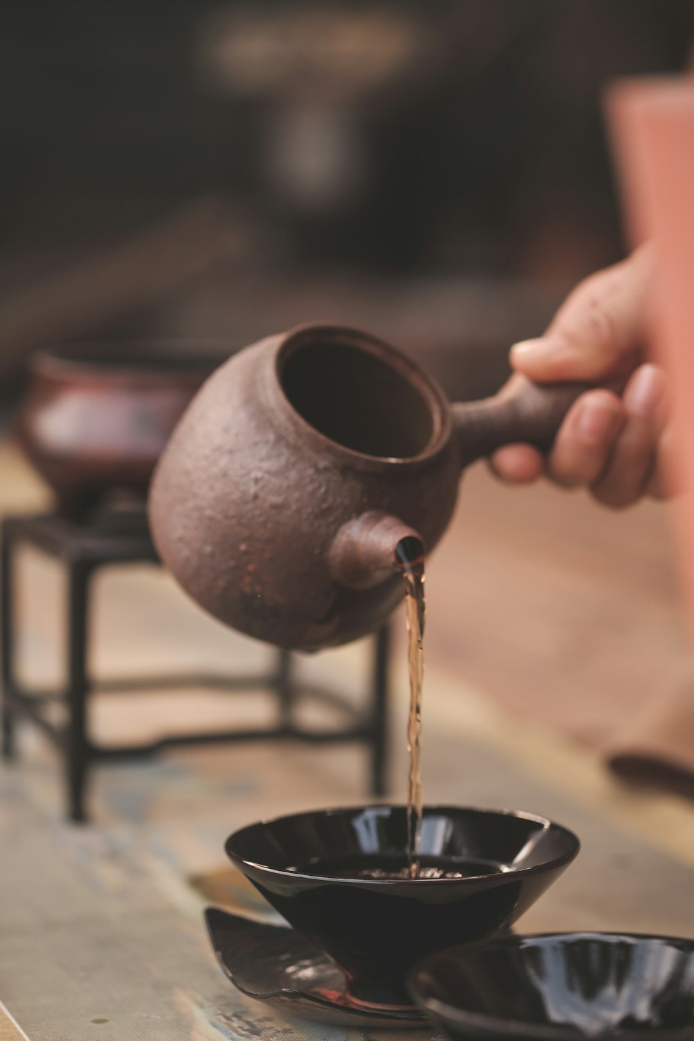 a person pouring coffee into a black bowl