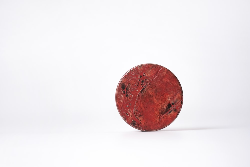 a red object sitting on top of a white surface