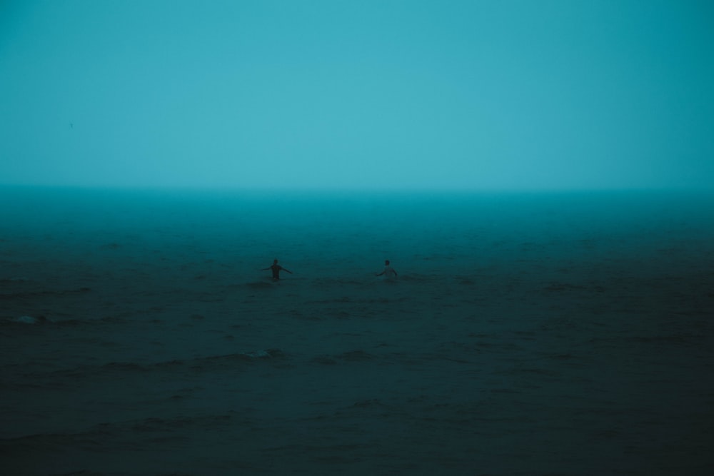 a couple of people standing on top of a large body of water