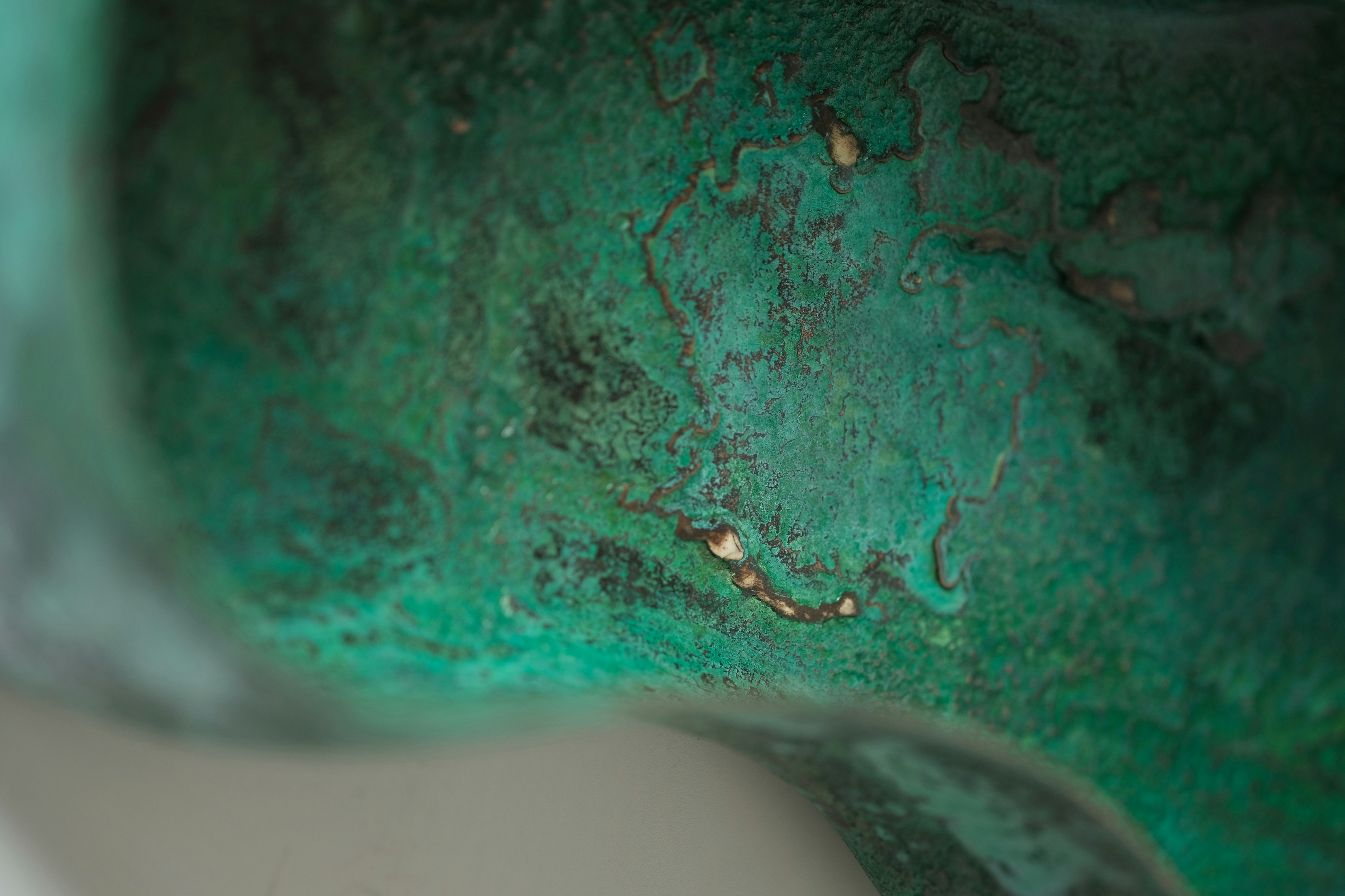 a close up of a green and white vase