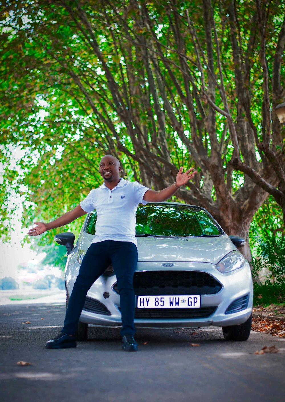 a man standing next to a silver car