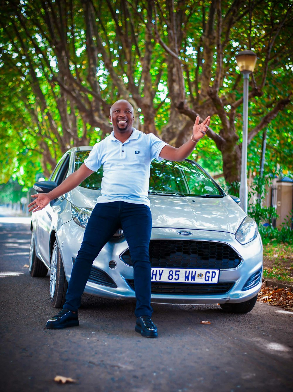 a man standing in front of a silver car