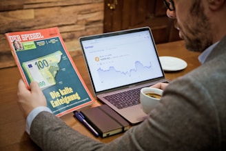 a man sitting at a table with a laptop and a book