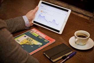 a person sitting at a table with a tablet and a cup of coffee