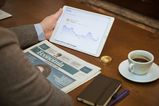 a person sitting at a table with a tablet and a cup of coffee