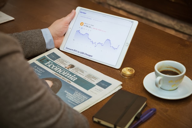 a person sitting at a table with a tablet and a cup of coffee