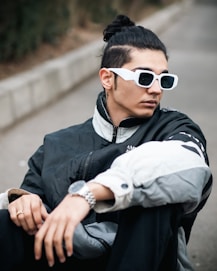 a man wearing sunglasses sitting on the ground
