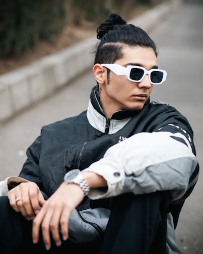a man wearing sunglasses sitting on the ground