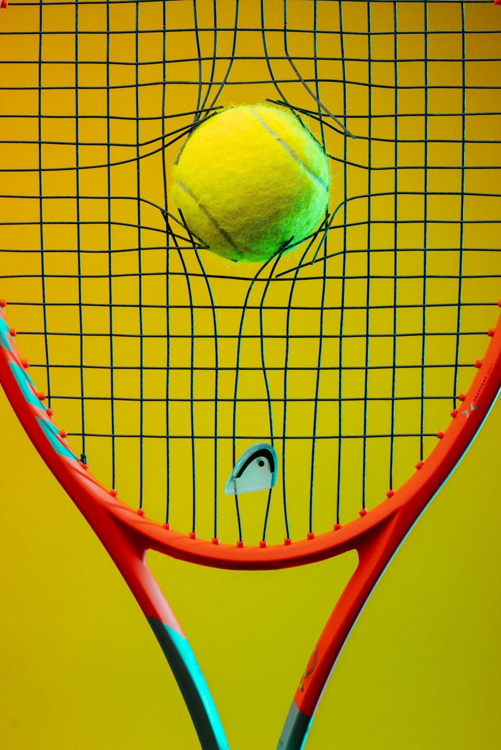uma raquete de tênis com uma bola de tênis sobre ela