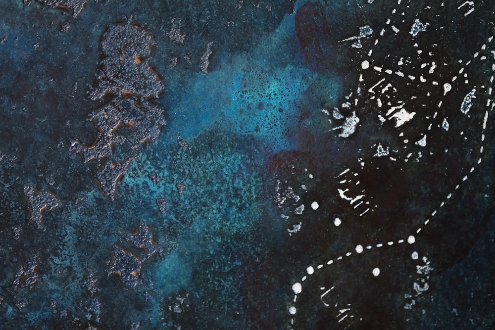 a blue and black painting with white dots on it