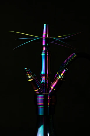 A stylish acrylic water pipe displayed on a modern black surface with neon accents.