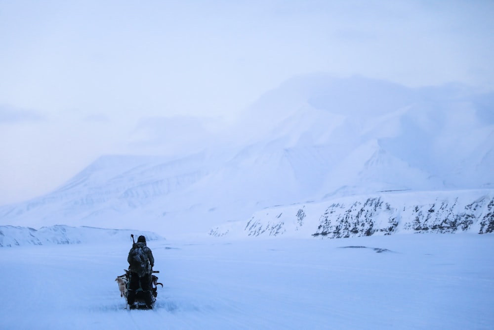 a man riding a snowboard across a snow covered field