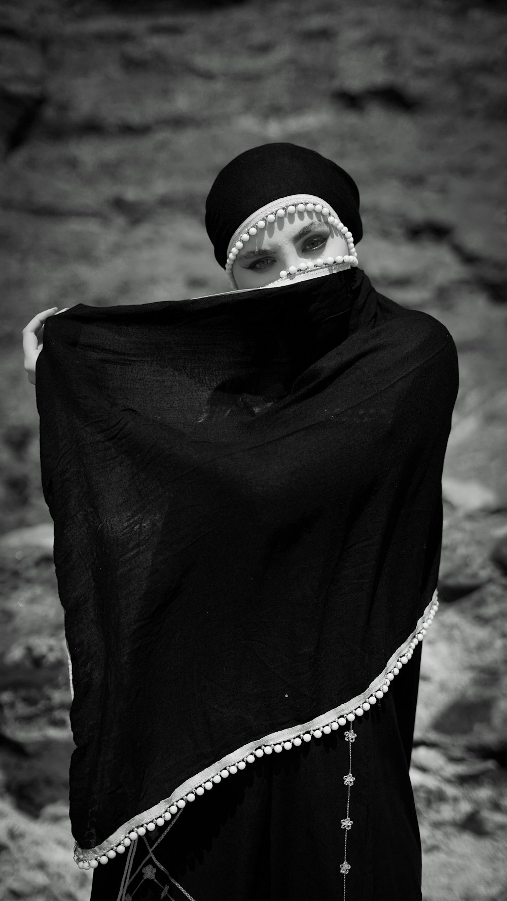 a woman wearing a black veil and a black cape