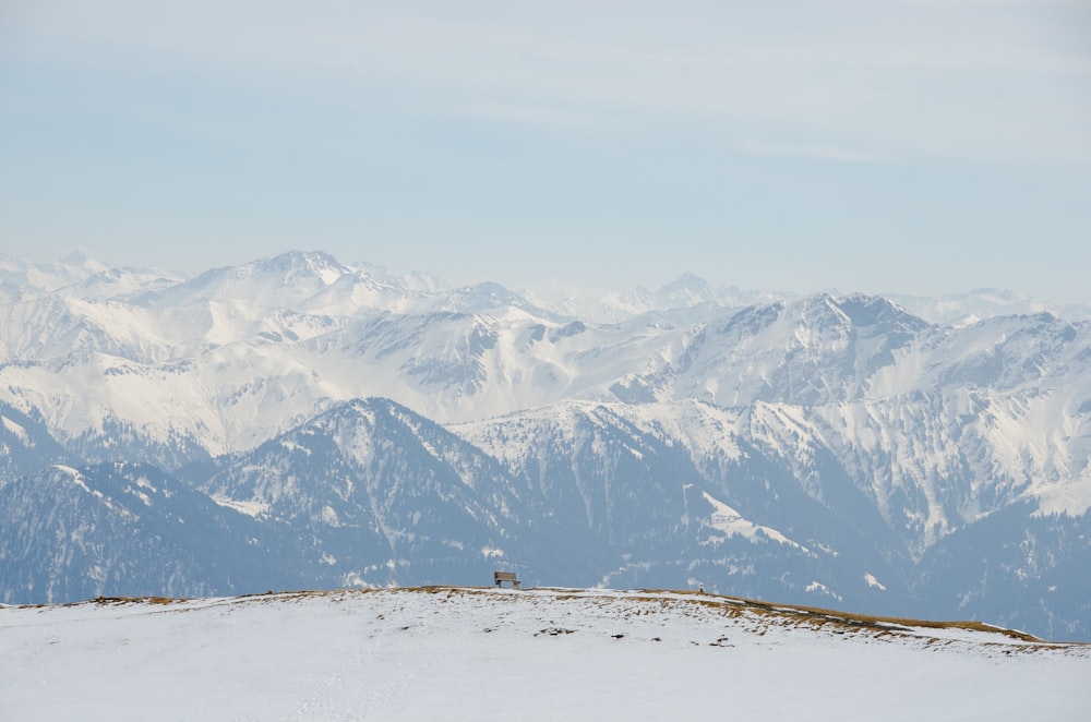 uma pessoa em pé no topo de uma montanha coberta de neve