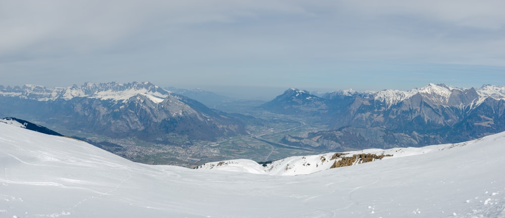 Un hombre montando esquís en la cima de una pendiente cubierta de nieve