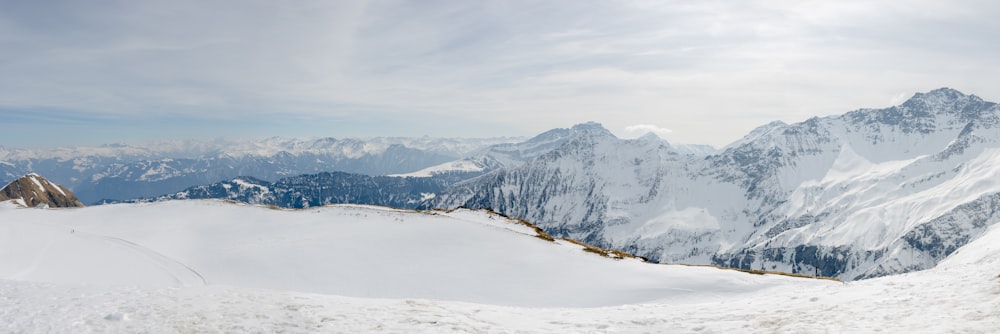 um homem montando esquis em cima de uma encosta coberta de neve