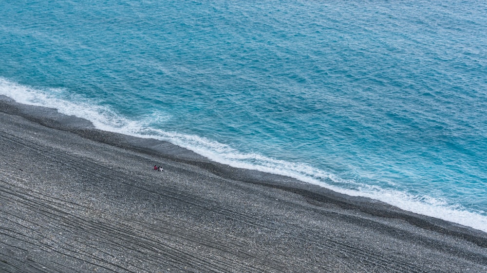 a person walking along a beach next to the ocean