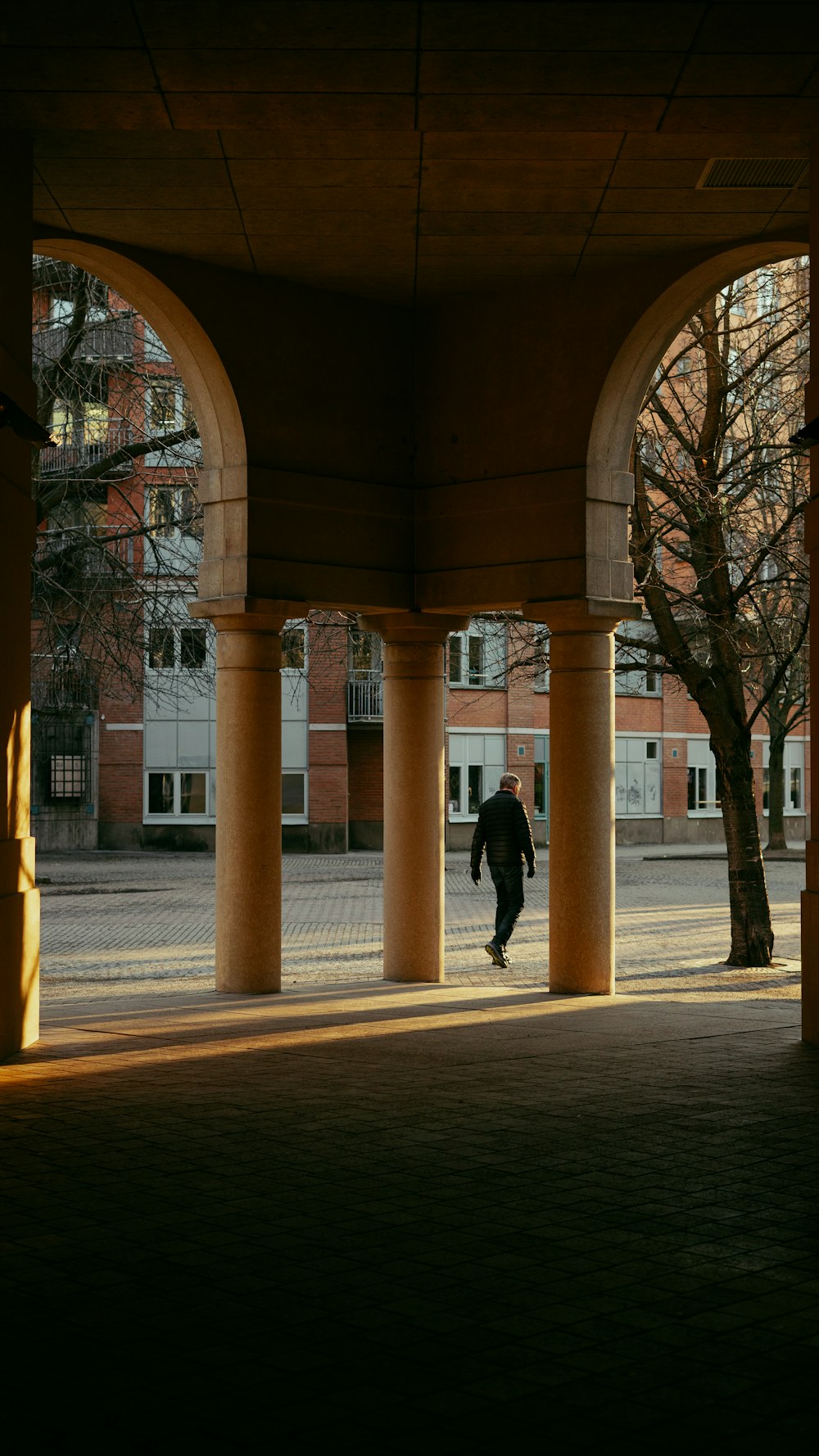 a man is walking under a large building