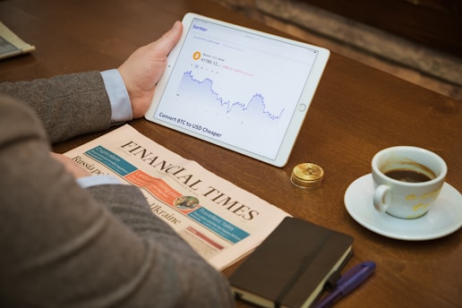 a person sitting at a table with a tablet and a cup of coffee