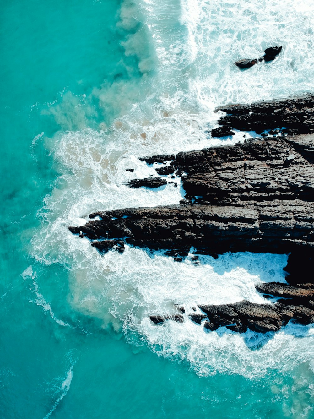 a bird's eye view of the ocean and rocks