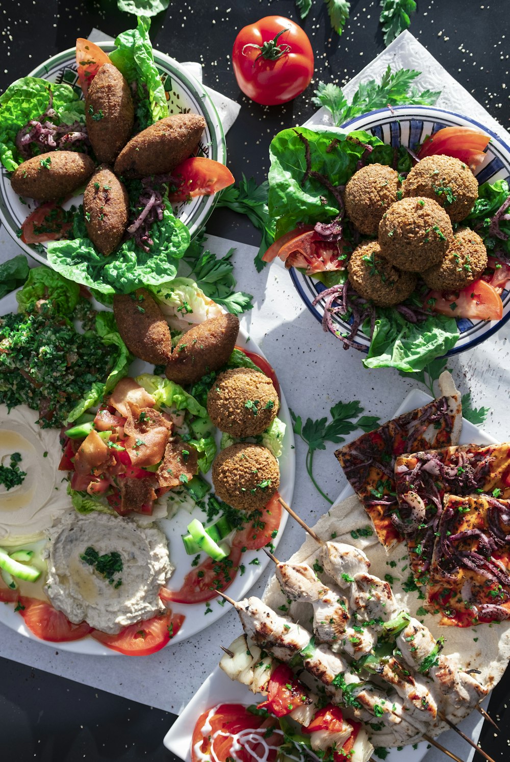 a table topped with plates of food covered in veggies