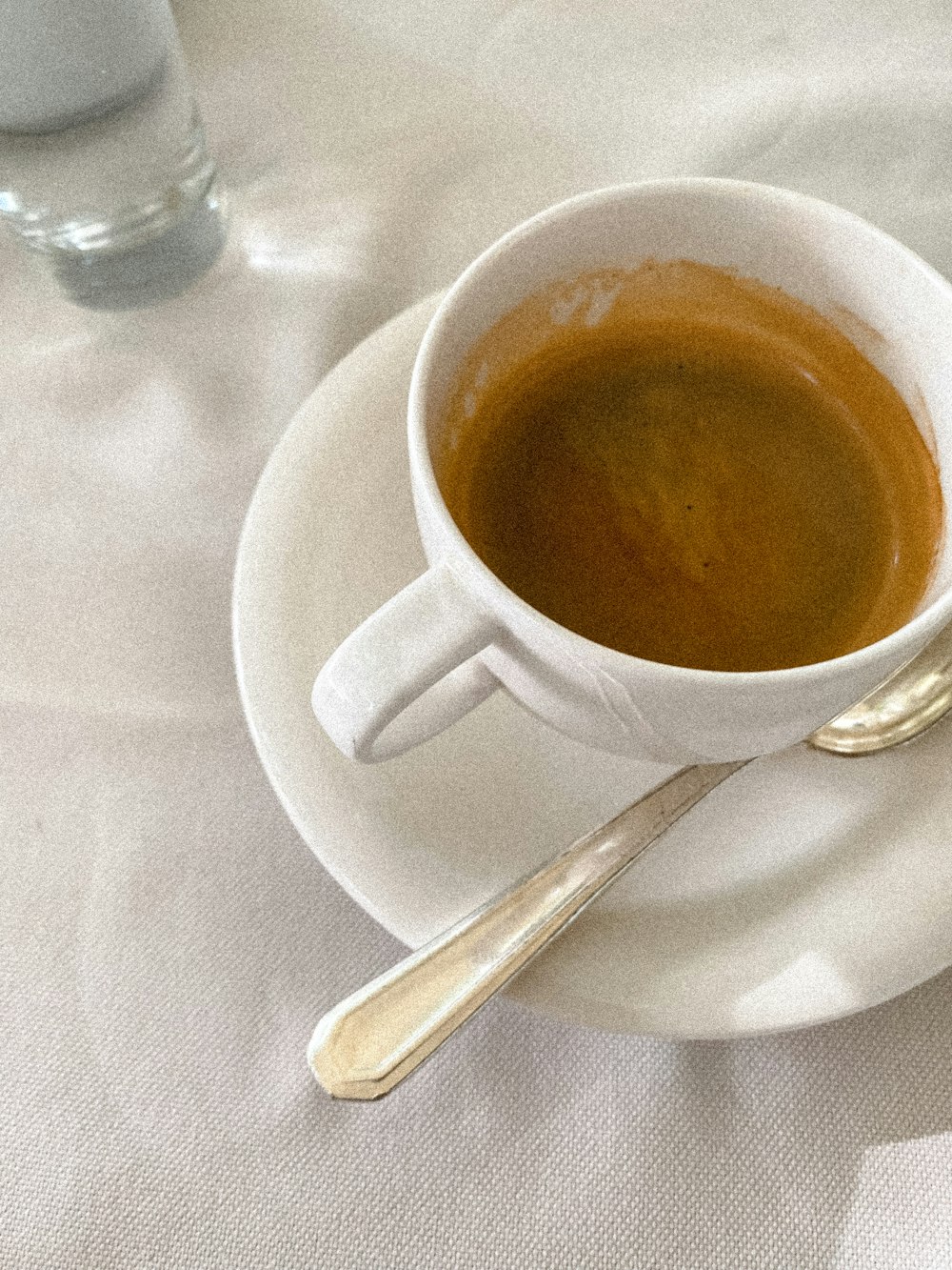 a cup of coffee sitting on top of a white saucer