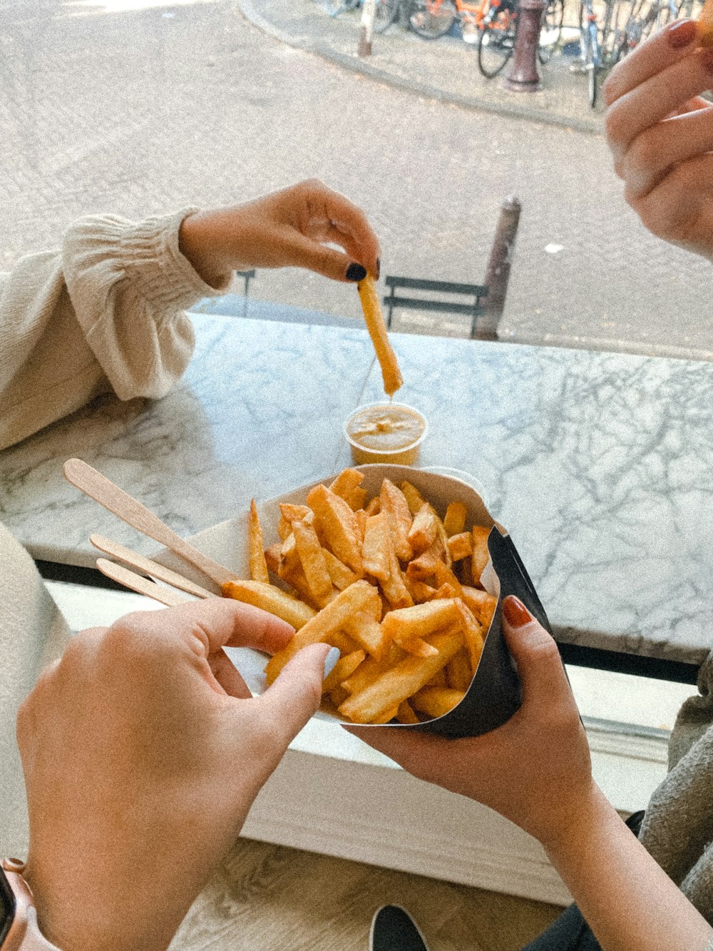a couple of people sitting at a table eating french fries