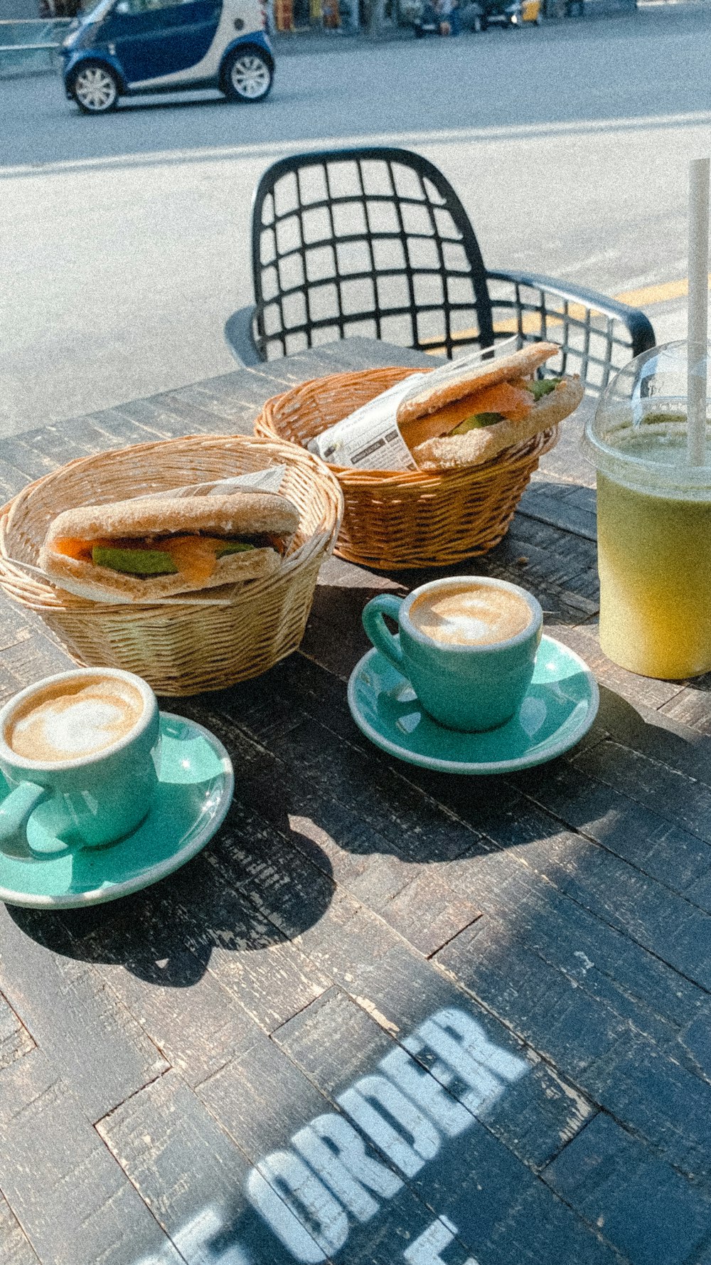 a table topped with cups of coffee and sandwiches
