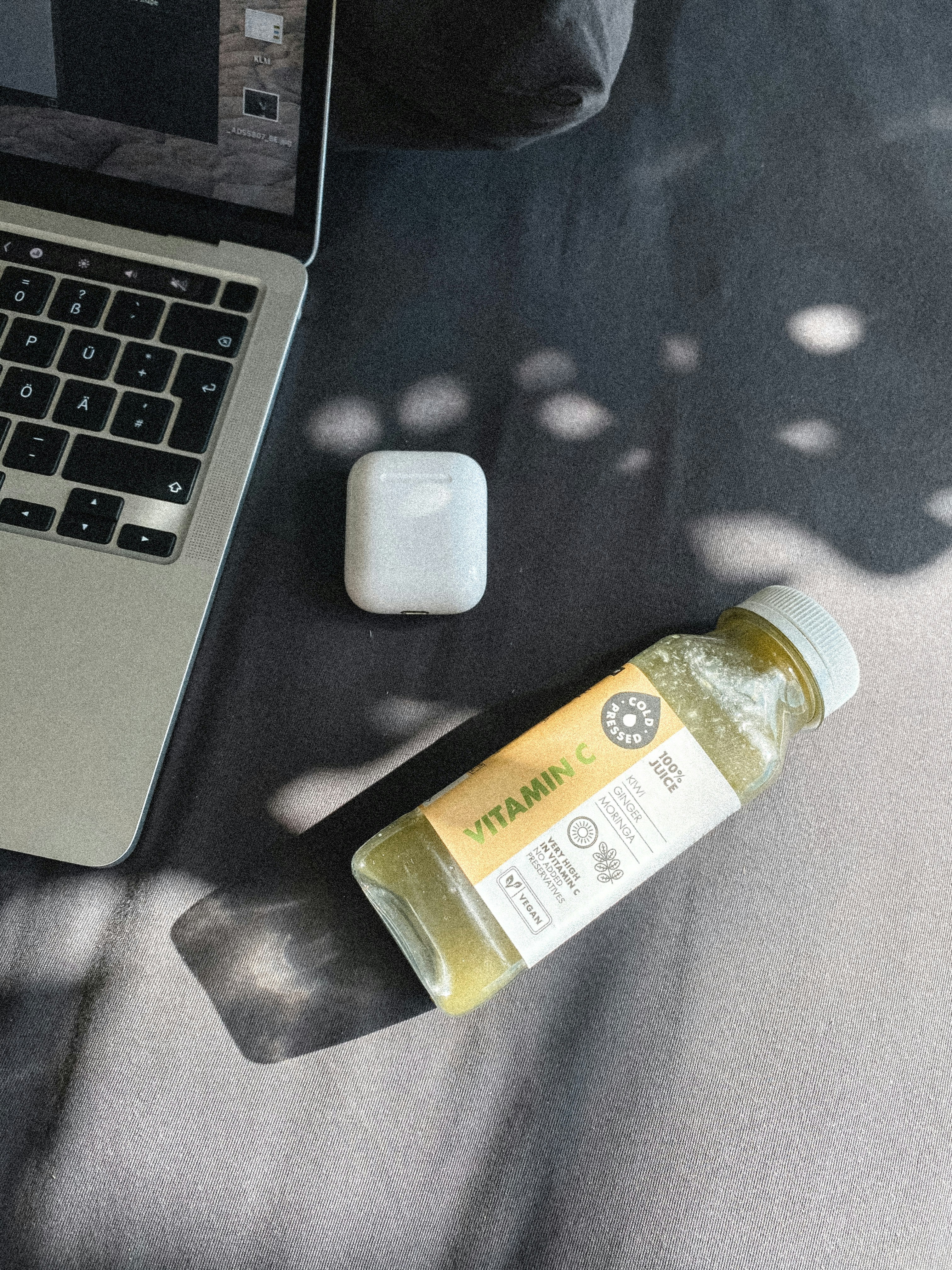Ein Laptop, der auf einem Tisch neben einer Flasche Flüssigkeit sitzt