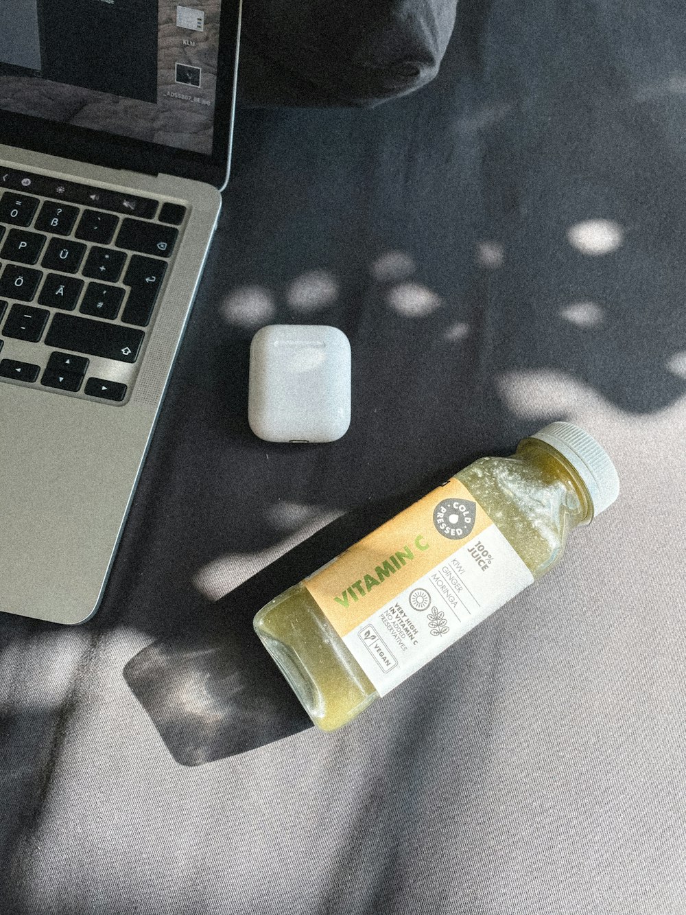 a laptop computer sitting on top of a table next to a bottle of liquid