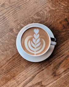 A freshly brewed cup of coffee with latte art on a saucer at Zucca Lounge.