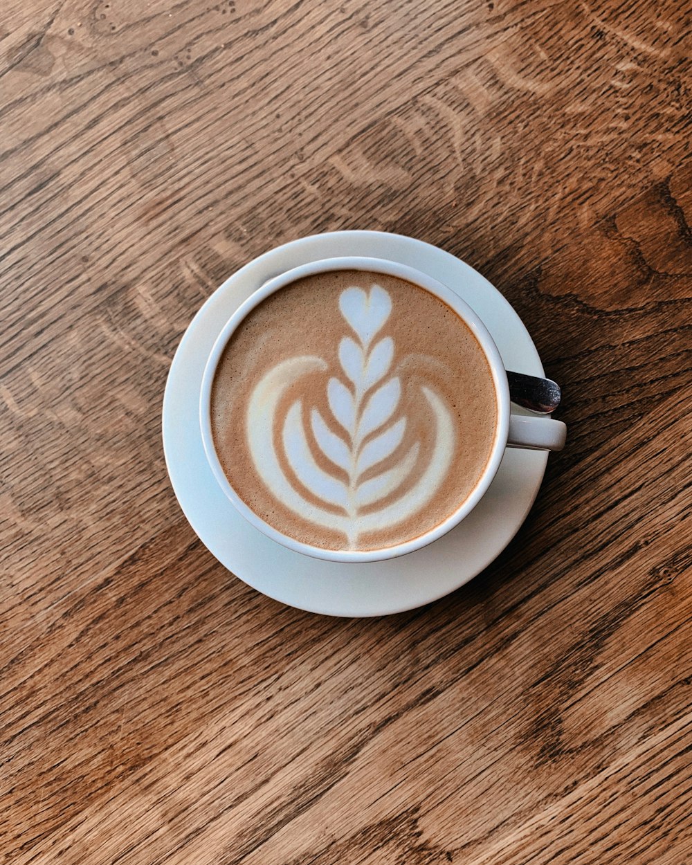 a cappuccino on a saucer on a wooden table