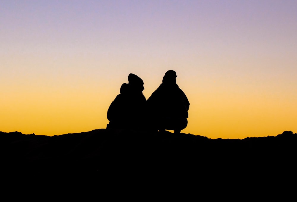 Un couple de personnes assises au sommet d’une colline