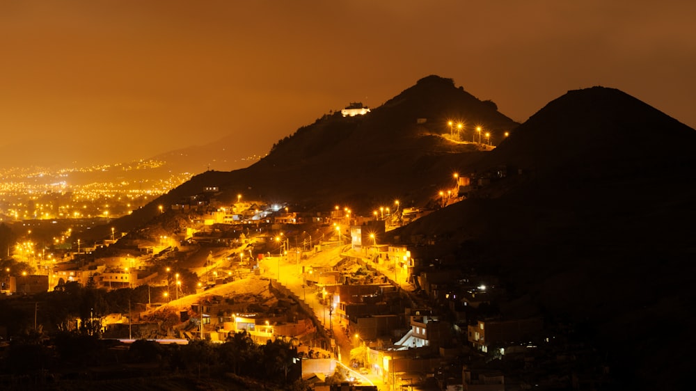 a night view of a city with a mountain in the background
