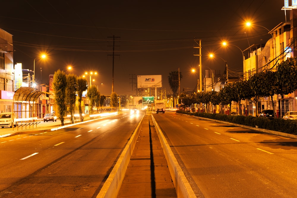 a city street at night with cars driving down it