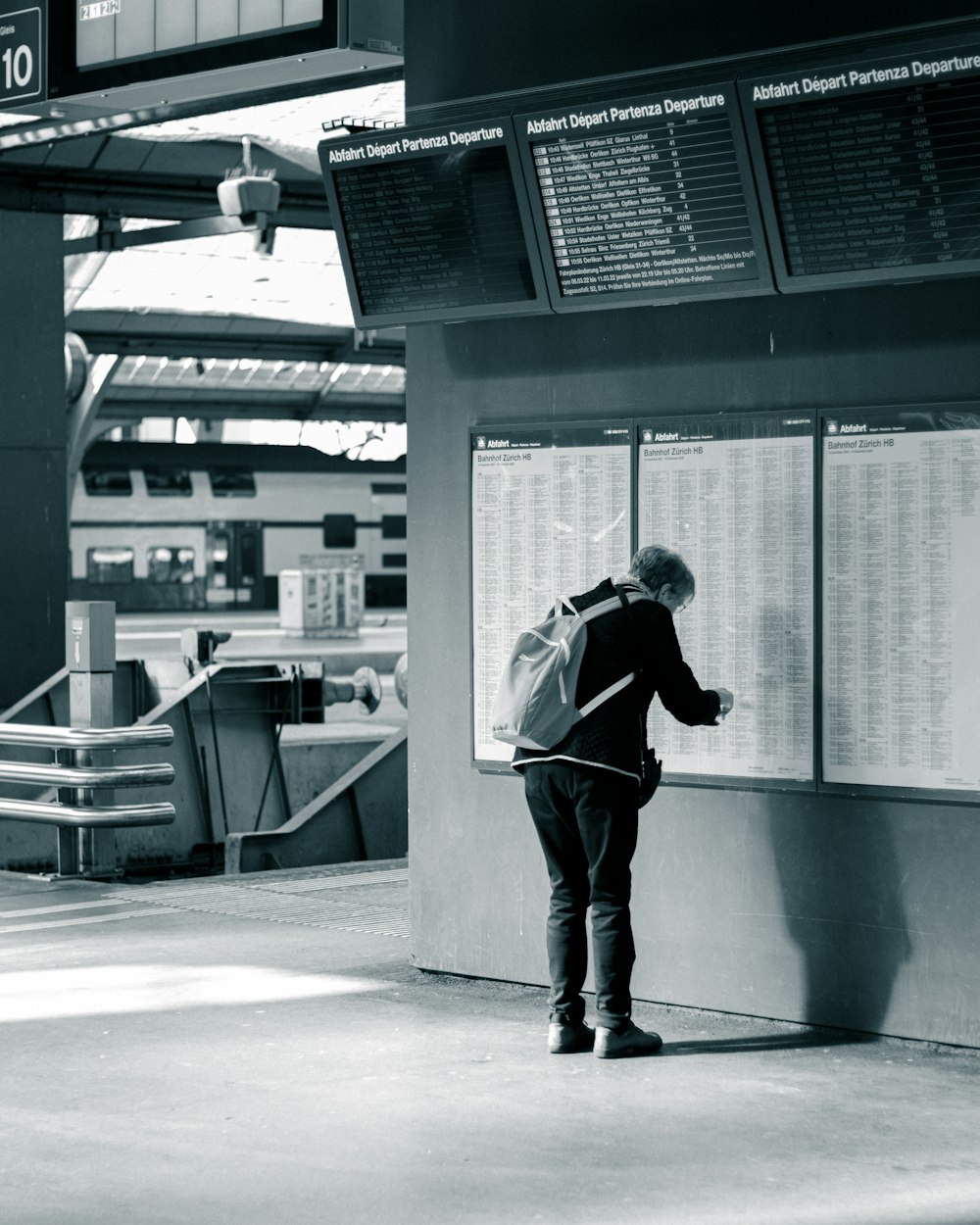 a man with a backpack standing in front of a sign