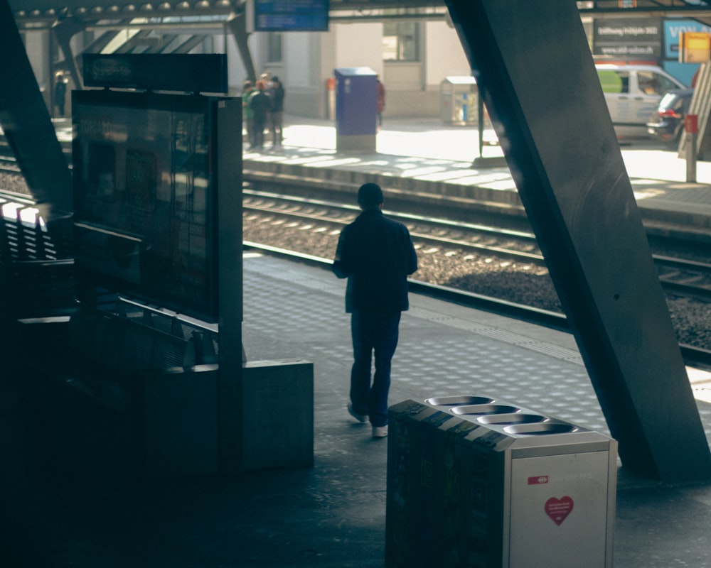 a person standing next to a train station platform