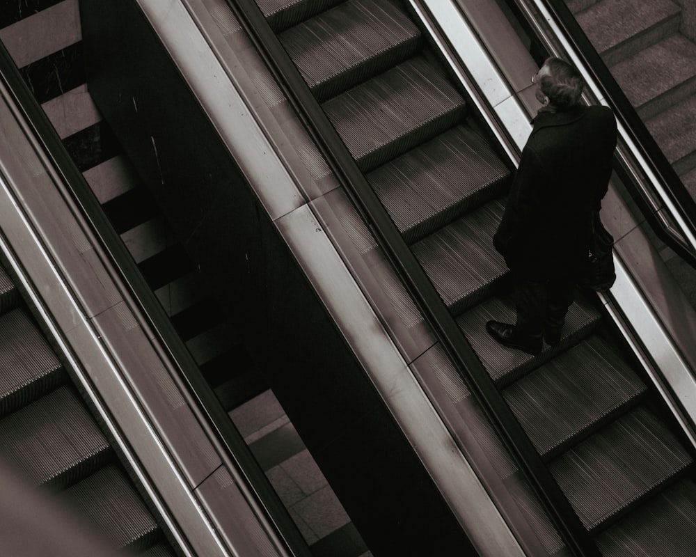 Un hombre caminando por una escalera mecánica en un edificio