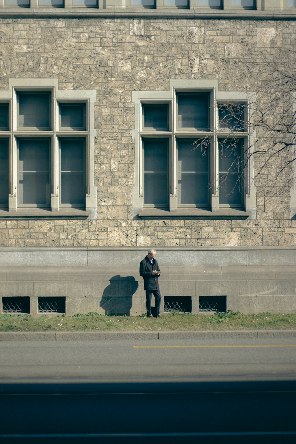 a man standing on the side of a road next to a building