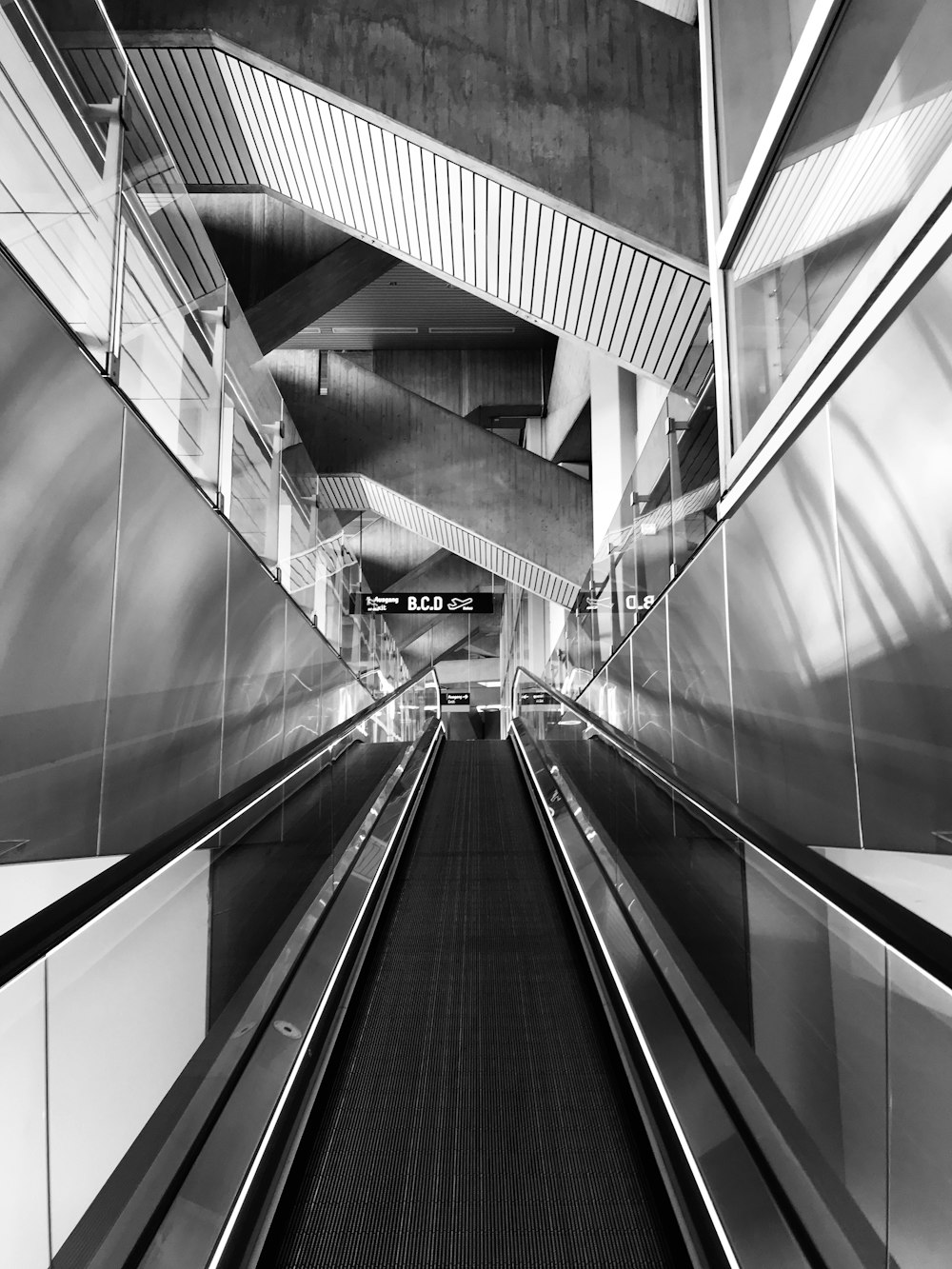 a black and white photo of an escalator