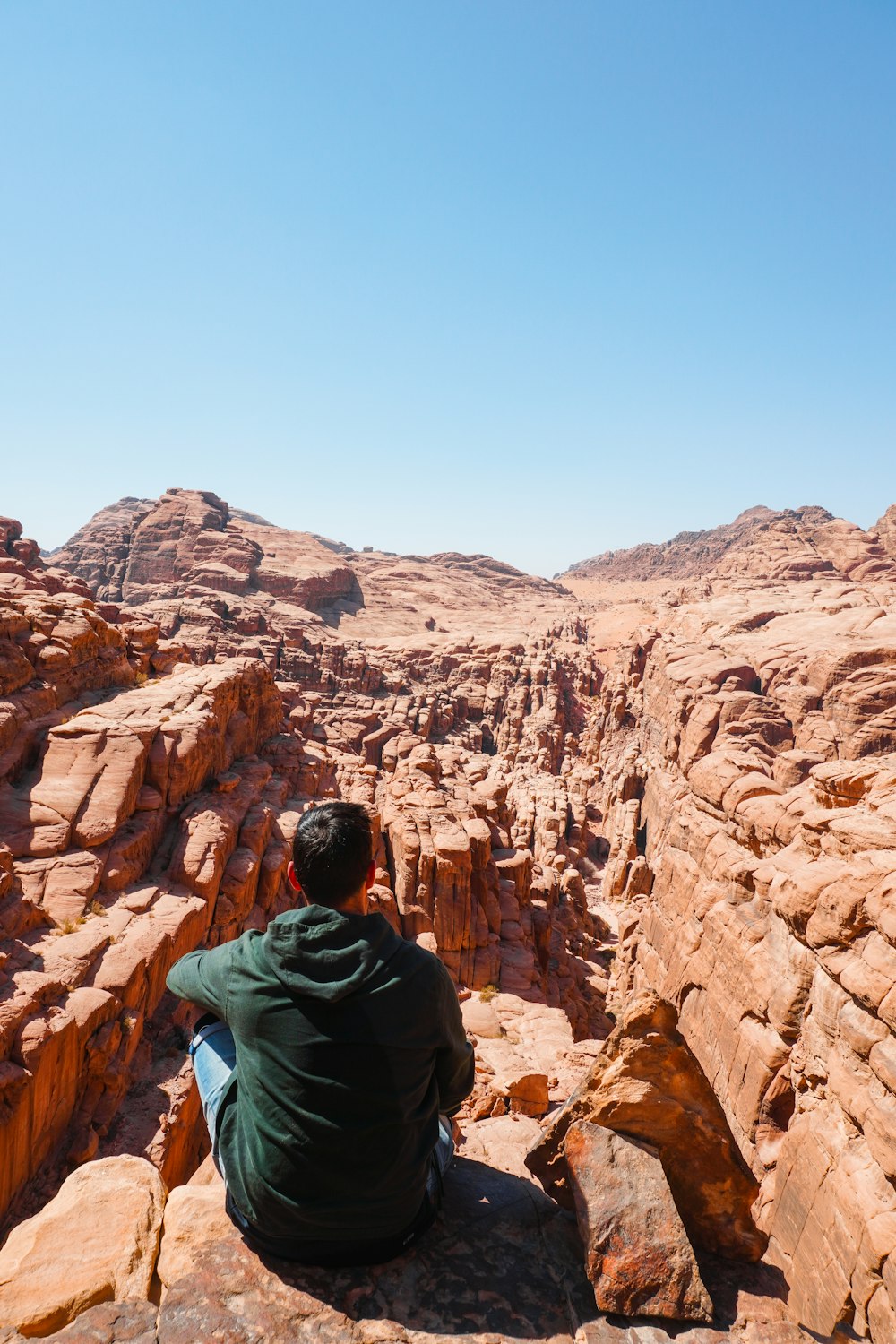 a man sitting on top of a rock formation