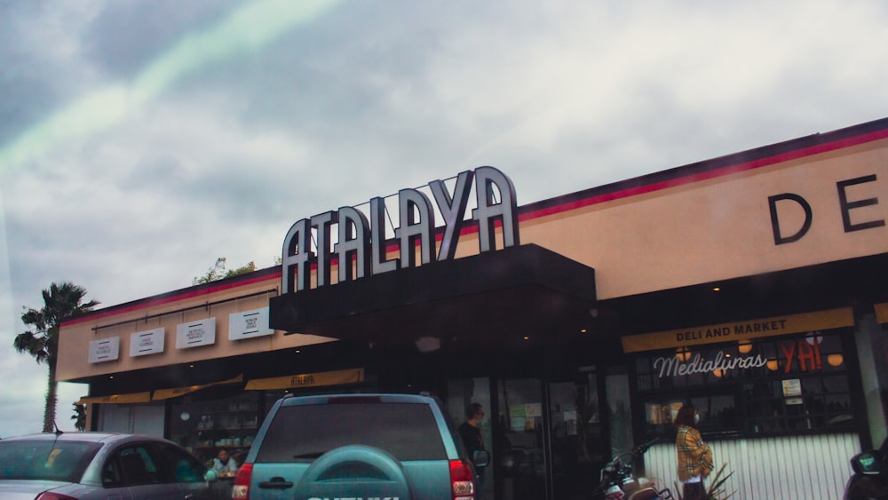 a car is parked outside of a deli