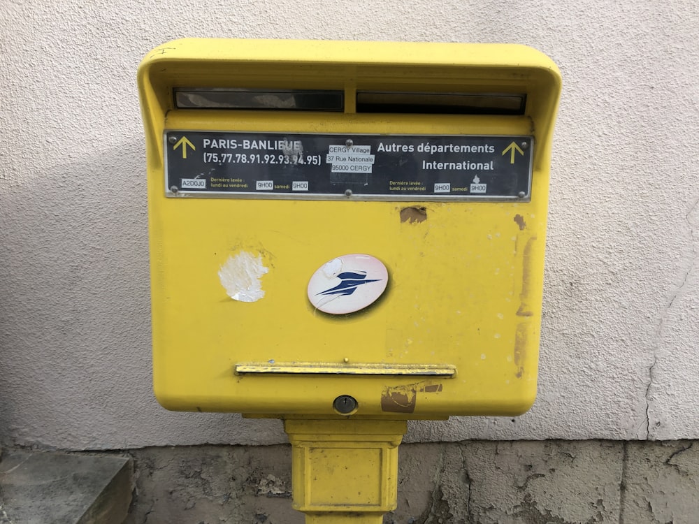 a close up of a yellow box on a street