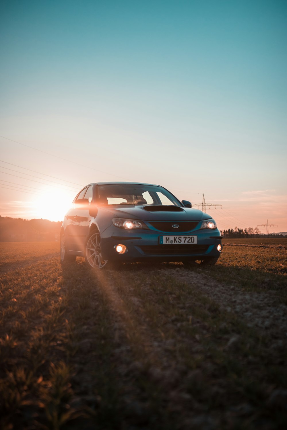 a car parked in a field at sunset