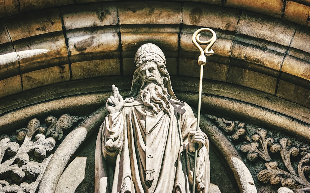 a statue of a man holding a staff