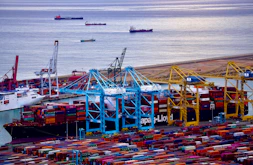 A bustling port with containers being loaded, symbolizing international trade.