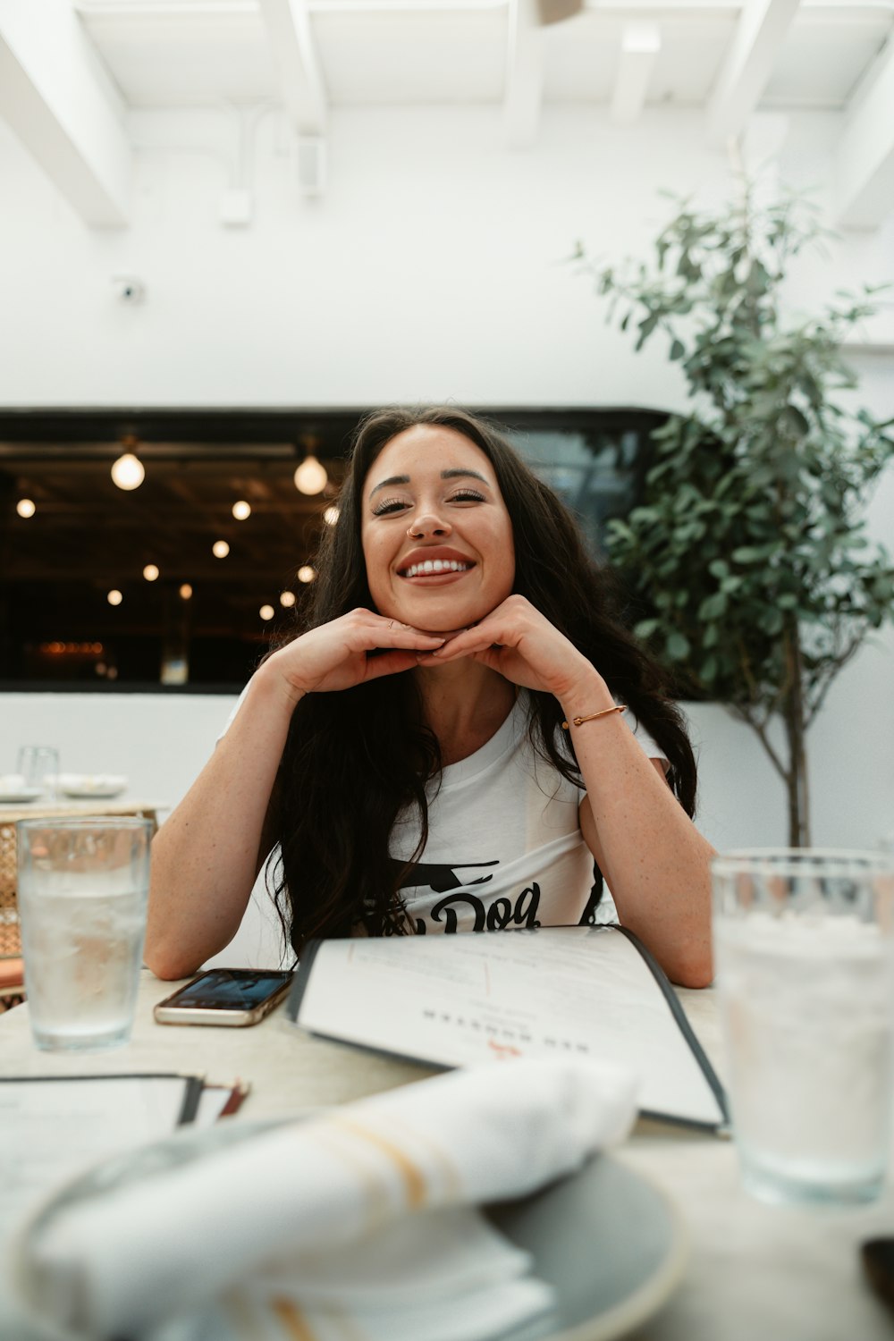 a woman sitting at a table with a glass of water