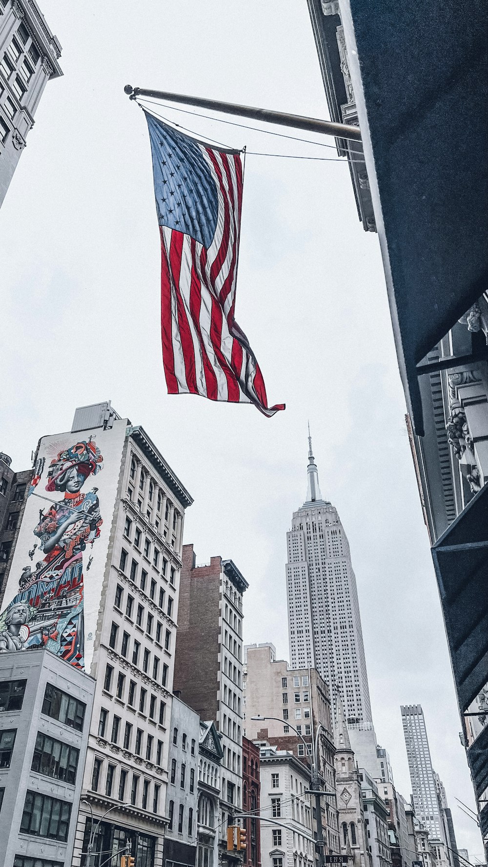 an american flag flying in the air over a city